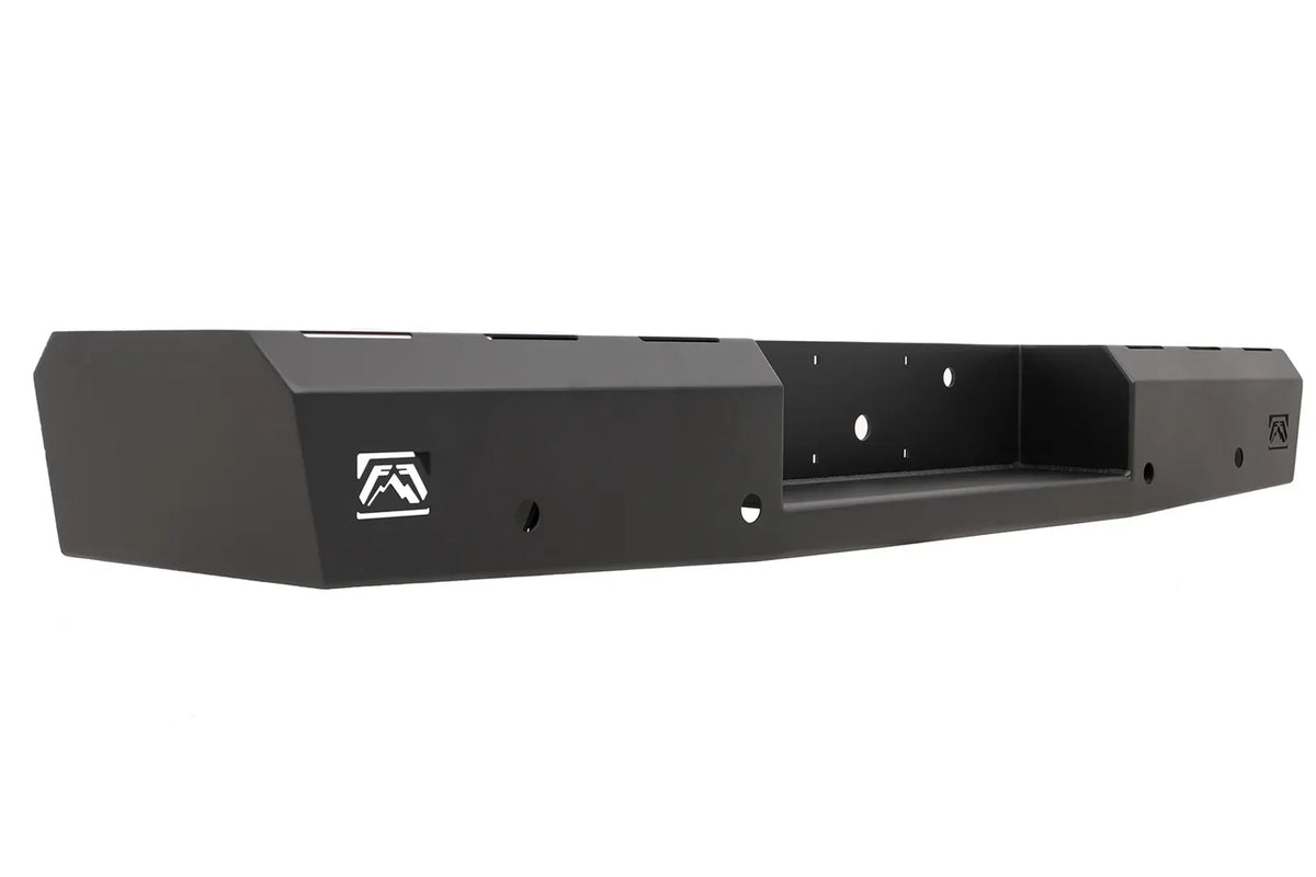 Fab Fours Red Steel rear bumper in black powder coat, angled view, showing the logo cutout end cap, recessed center hitch pocket and light mounting holes