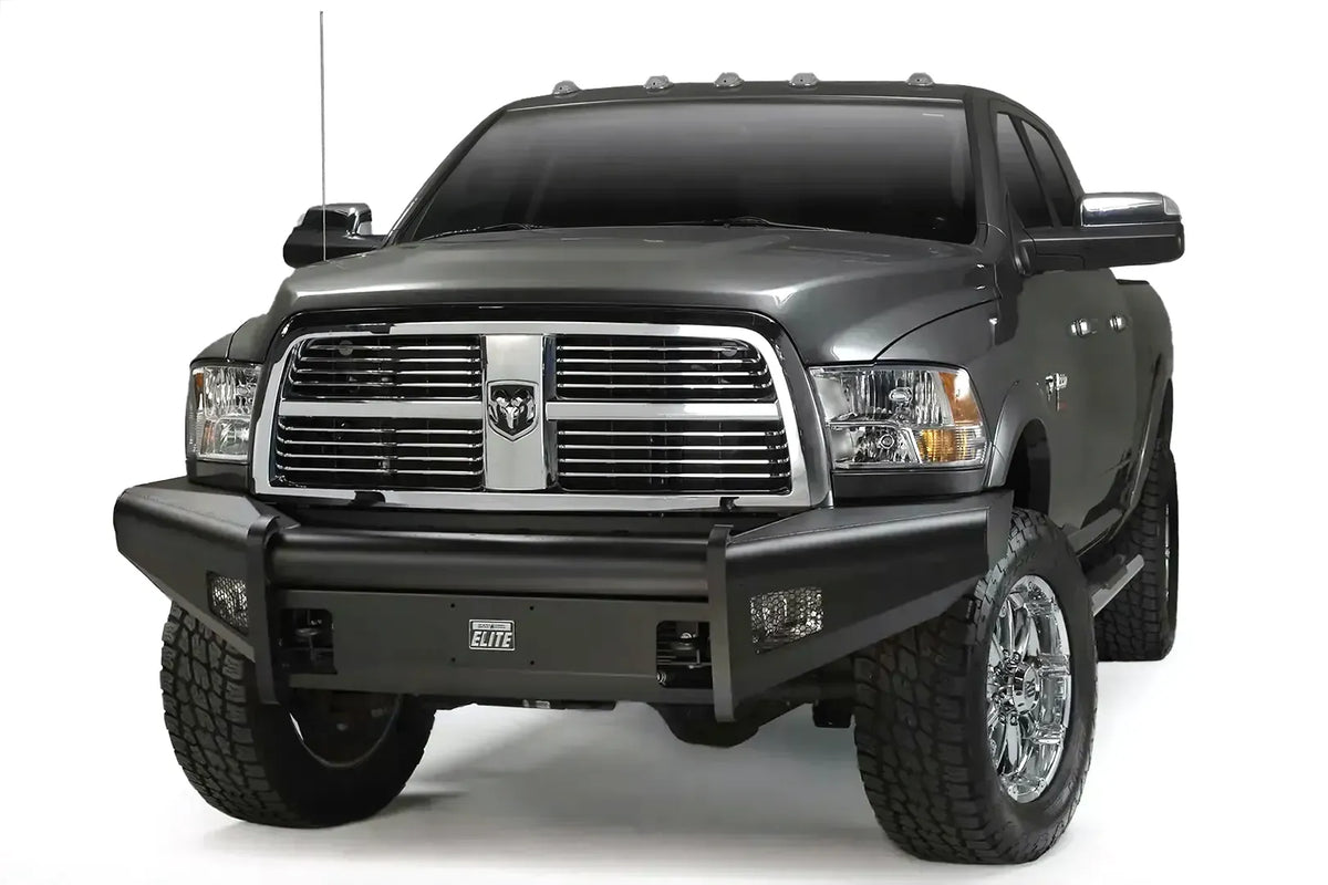 Fab Fours Black Steel Elite front bumper on a gray Ram 2500, front driver-side three-quarter view, showing the smooth plated face, Elite badge, and integrated light openings