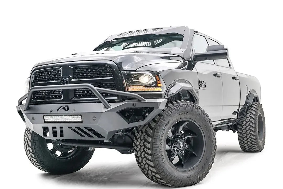 Fab Fours Open Fender front bumper on a gray lifted Ram 2500, front driver-side three-quarter view, showing the pre-runner hoop, integrated light bar and open fender cutaway