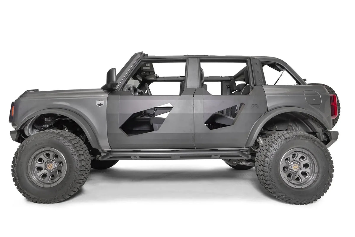 Fab Fours Trail Door Inserts on a gray four-door Ford Bronco, driver-side profile, showing the black steel inserts with angled window cutouts on the front and rear trail doors