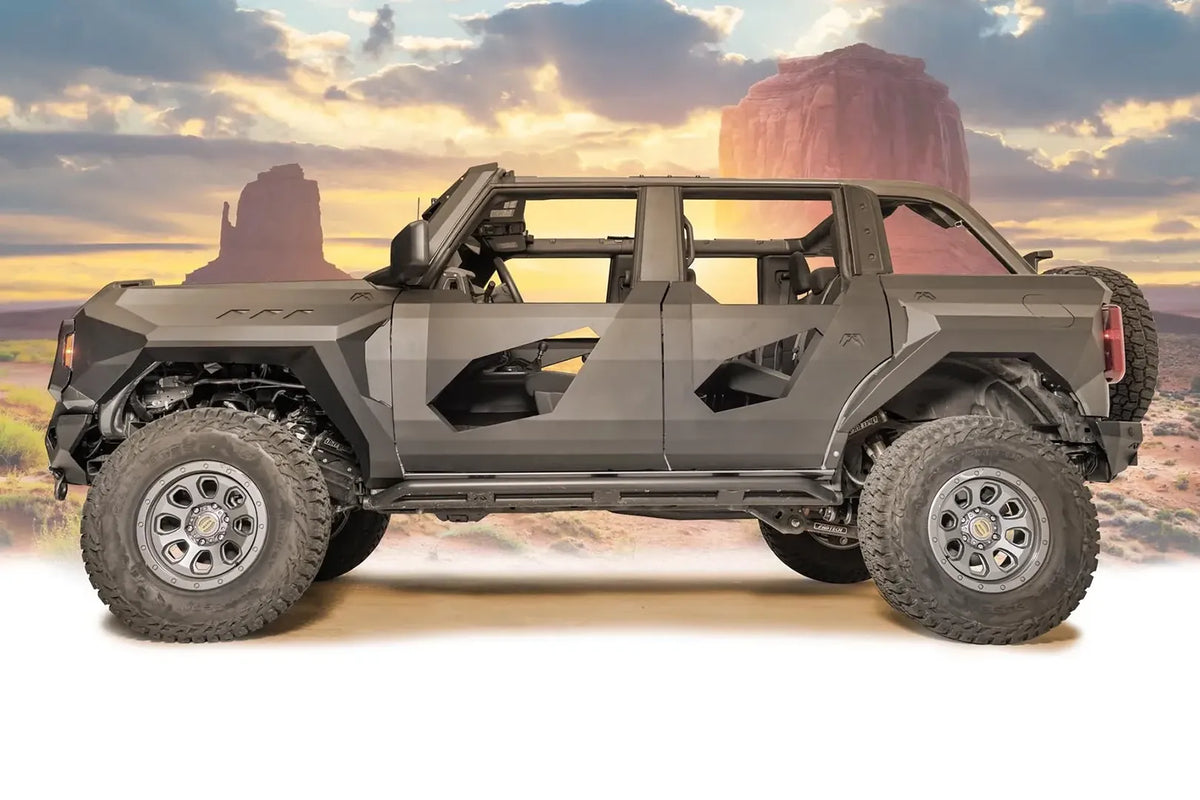 Fab Fours front and rear steel fenders on a lifted gray Ford Bronco with doors removed and Fab Fours body armor, driver-side profile view with desert background