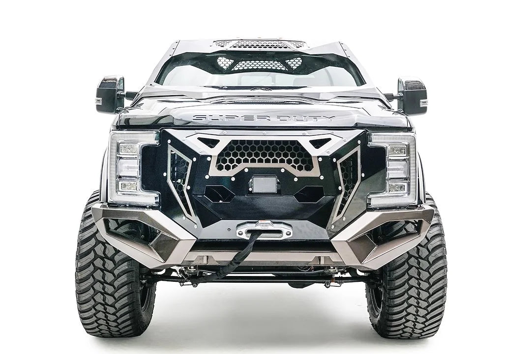 Fab Fours Open Fender front bumper on a dark gray Ford Super Duty, straight-on front view, showing a mesh-panel grille guard, the center winch with fairlead, and angular steel wings