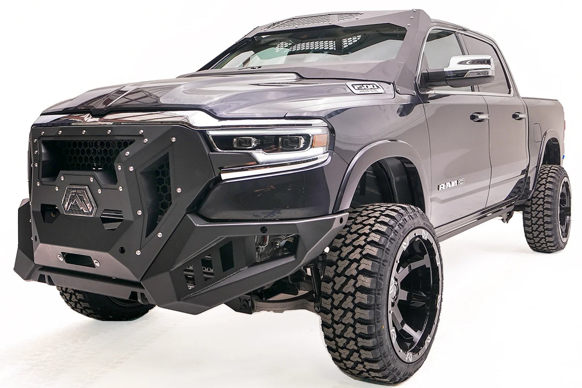 Fab Fours Grumper front winch bumper with honeycomb mesh grille on a lifted dark gray Ram 1500, driver-side front three-quarter view