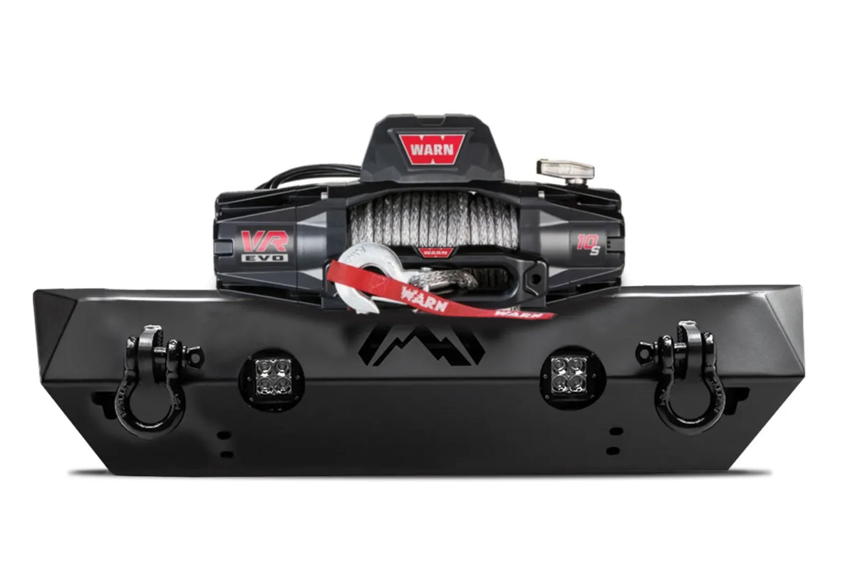 Fab Fours Hardcore Stubby Winch bumper in black powder coat, front view, showing the winch mount with winch installed, cube light cutouts and D-ring shackles