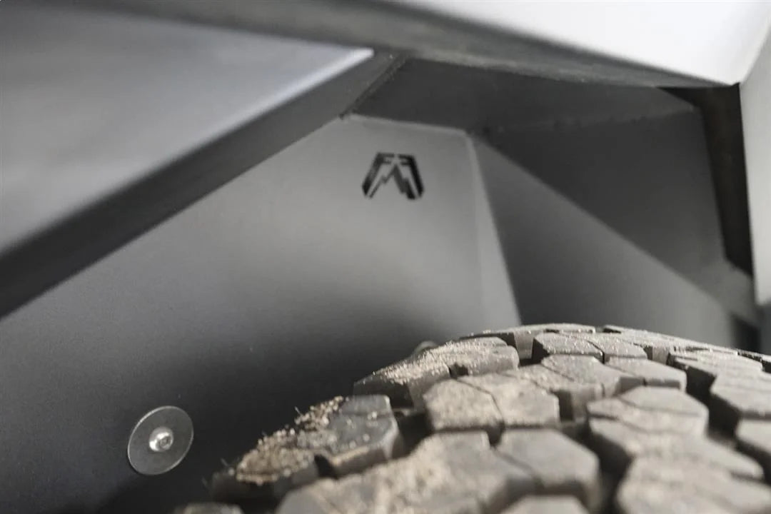Close-up of Fab Fours inner fender liner with Fab Fours logo cutout above the rear tire of a Jeep Wrangler JL