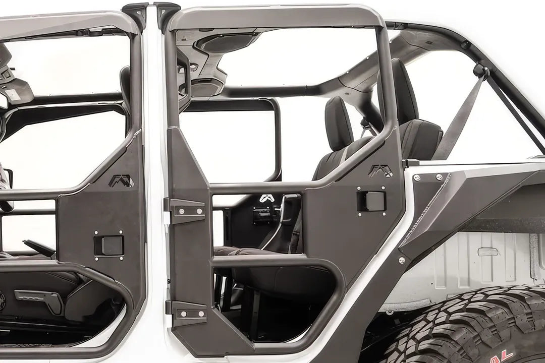 Fab Fours full rear tube door on a white Jeep Wrangler JL Unlimited, driver-side close-up, showing the tubular frame, steel lower panel, paddle latch and Fab Fours logo
