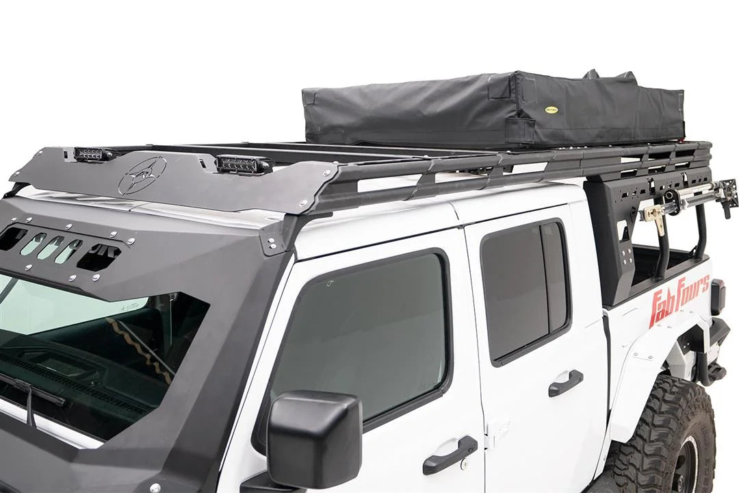 Fab Fours Overland Rack extension on a white Jeep Gladiator, driver-side view, showing the front wind fairing with compass logo, two LED light bars and the rack connecting over the cab to the bed rack