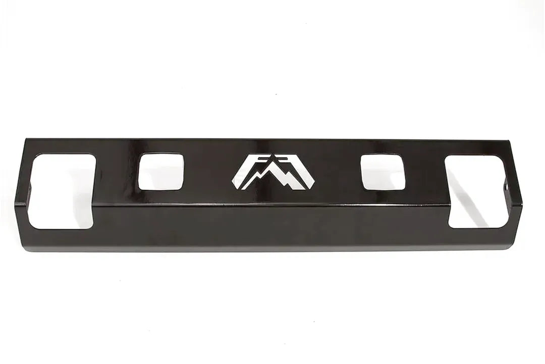 Fab Fours steel lower guard with light cut-outs in gloss black powder coat, straight-on front view, showing two square pod light openings beside the cut-out Fab Fours logo and the shackle openings at each end