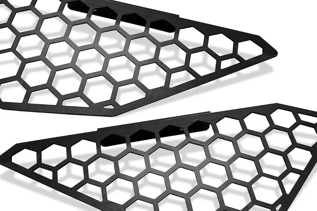 Fab Fours side light mesh insert covers for the 2019 Ford Ranger Vengeance bumper in black powder coat, close-up of the pair at an angle, showing the honeycomb cut-out pattern and the angled mounting tabs