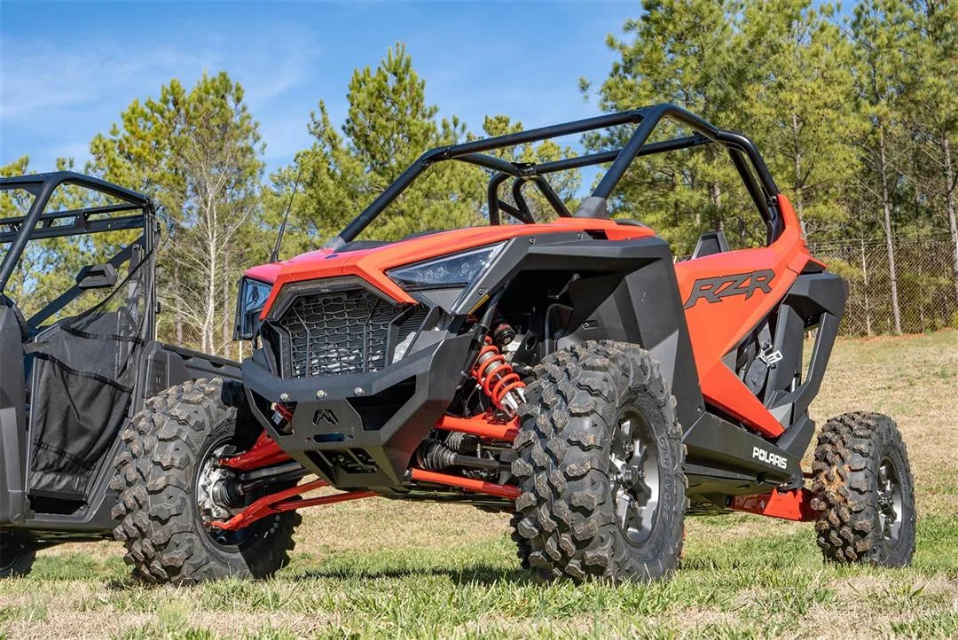 Fab Fours SxS winch bumper on an orange Polaris RZR Pro XP parked on grass, driver-side front three-quarter view