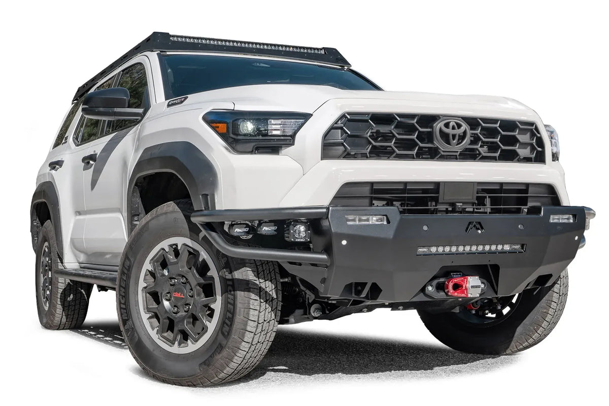 Fab Fours Hybrid front bumper on a white Toyota 4Runner, front three-quarter view from the passenger side, showing the tube wings, LED light bar and cube lights