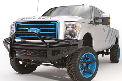 Fab Fours Black Steel front guard plate on a silver Ford Super Duty, front driver-side three-quarter view, showing the diamond-plate guard plate, pre-runner guard tubing and black steel front bumper