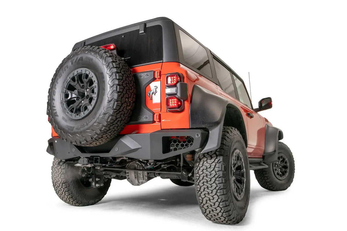 Fab Fours Vengeance rear bumper on an orange Ford Bronco Raptor, passenger-side rear three-quarter view