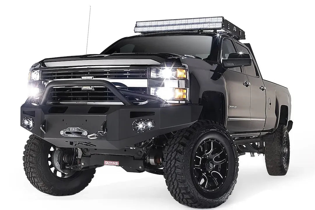 Fab Fours Premium heavy-duty winch front bumper with pre-runner guard on a lifted black Chevrolet Silverado 2500HD, driver-side front three-quarter view