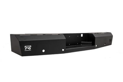 Fab Fours Red Steel rear bumper in black powder coat, angled view, showing the recessed center step, Fab Fours logo plates and light cutouts