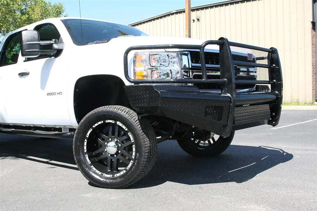 Fab Fours Black Steel front bumper with full guard on a white Chevrolet Silverado 2500HD, front passenger-side three-quarter outdoor view, showing the full grille guard, diamond-plate bumper face and wrap-around end