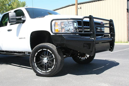 Fab Fours Black Steel front bumper with full guard on a white Chevrolet Silverado 2500HD, front passenger-side three-quarter outdoor view, showing the full grille guard, diamond-plate bumper face and wrap-around end