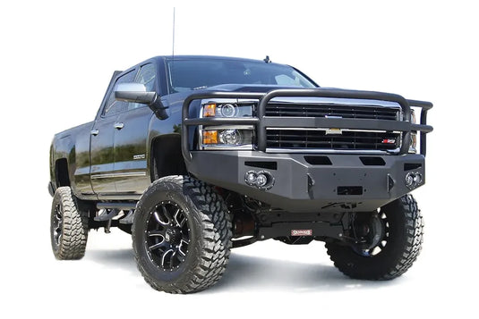 Fab Fours Premium heavy-duty winch front bumper with full grille guard on a lifted black Chevrolet Silverado 2500HD, passenger-side front three-quarter view
