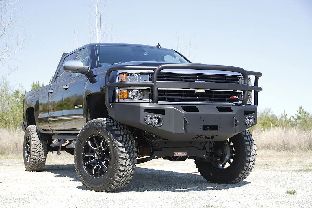 Fab Fours Premium heavy-duty winch front bumper with full grille guard on a lifted black Chevrolet Silverado 2500HD, passenger-side front three-quarter view