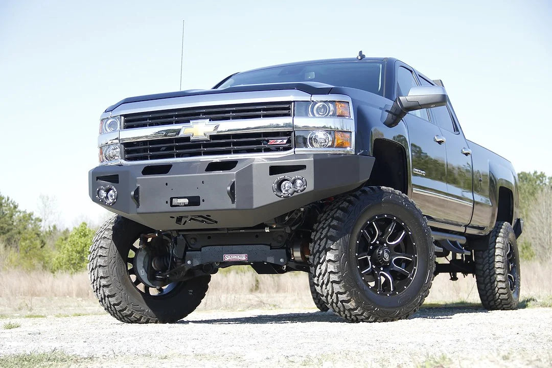 Fab Fours Premium heavy-duty winch front bumper on a lifted black Chevrolet Silverado 2500HD, driver-side front three-quarter view