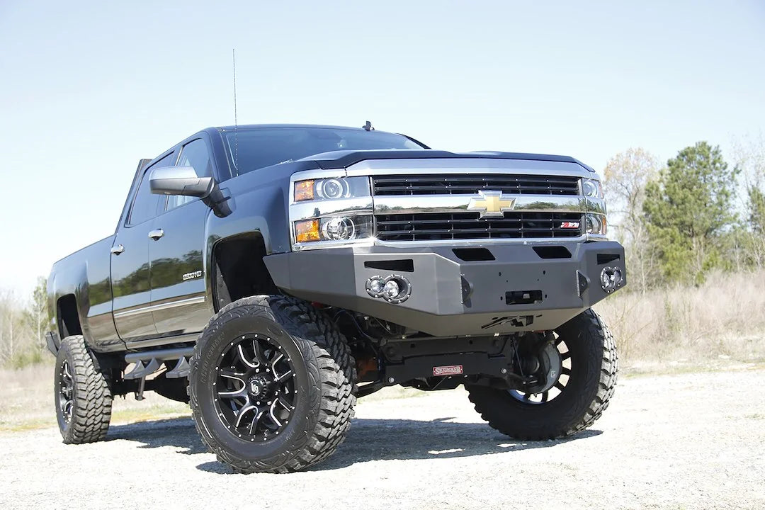 Fab Fours Premium heavy-duty winch front bumper on a lifted black Chevrolet Silverado 2500HD, passenger-side front three-quarter view