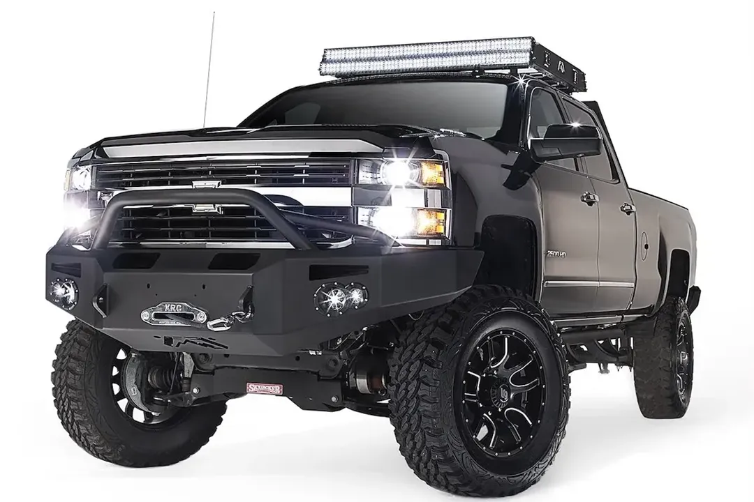 Fab Fours Premium heavy-duty winch front bumper with pre-runner guard on a lifted black Chevrolet Silverado 2500HD, driver-side front three-quarter view,