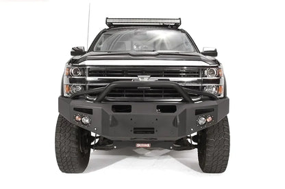 Fab Fours Premium Winch front bumper with pre-runner guard on a black Chevrolet Silverado 2500HD, straight-on front view, showing the pre-runner guard tubing, center winch plate, round lights and shackle mounts