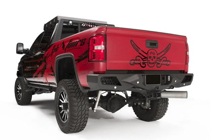 Fab Fours Vengeance rear bumper on a red GMC Sierra 2500HD, rear driver-side three-quarter view, showing the honeycomb light pods, angular end caps and license plate recess