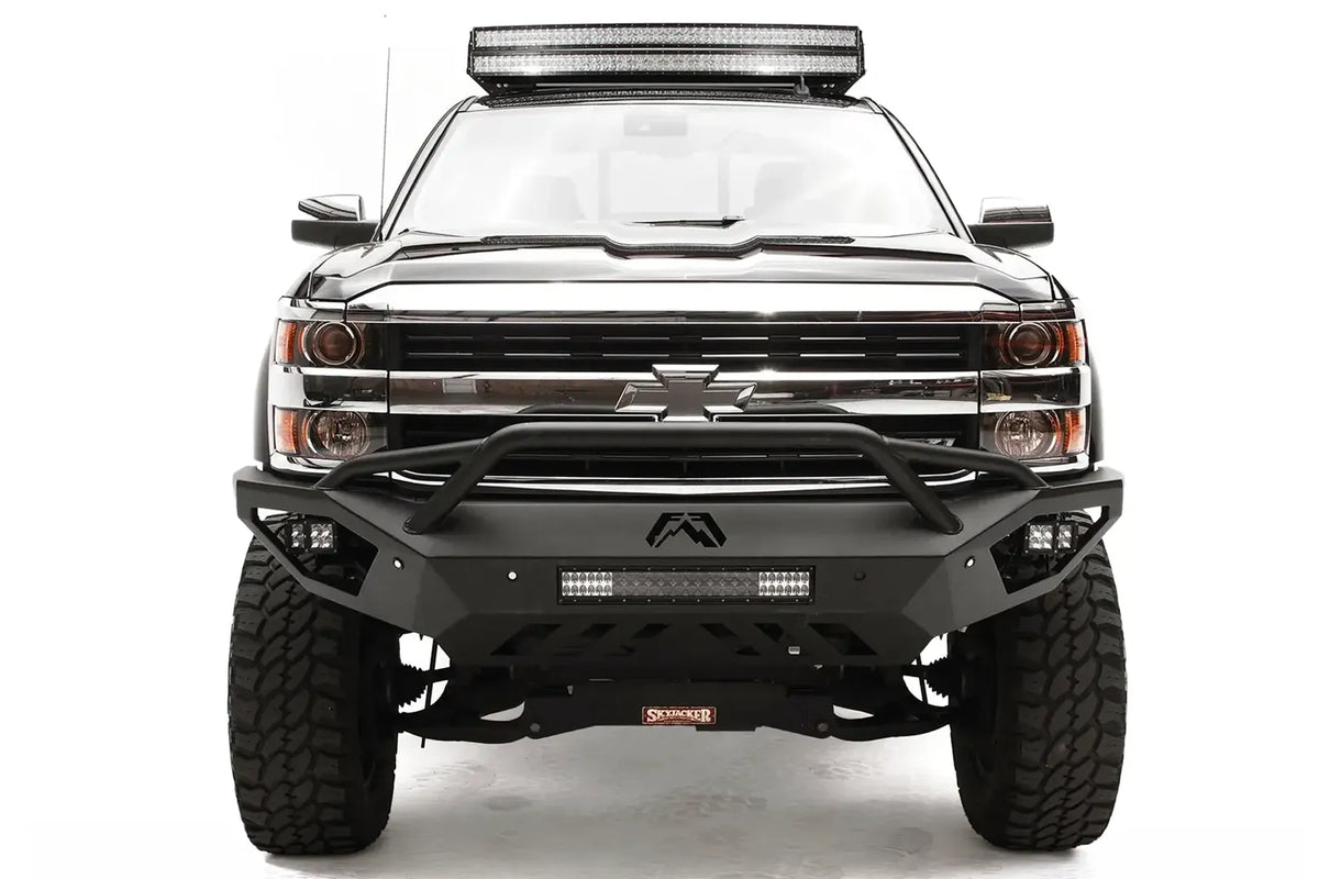 Fab Fours Vengeance front bumper with pre-runner guard on a black Chevrolet Silverado 2500HD, straight-on front view, showing the pre-runner guard tubing, Fab Fours logo, cube light pods and center light bar