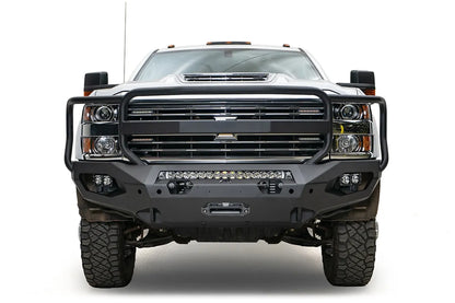 Fab Fours Matrix front bumper with full guard on a white Chevrolet Silverado 3500HD, straight-on front view, showing the full grille guard hoops, center light bar, cube light pods and winch fairlead