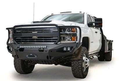 Fab Fours Matrix front bumper with full guard on a white Chevrolet Silverado 3500HD, front passenger-side three-quarter view, showing the full grille guard, center light bar, cube light pods and winch fairlead