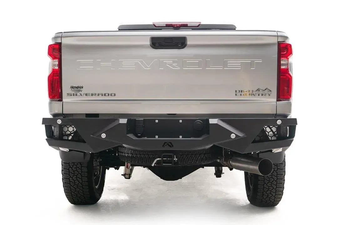 Fab Fours Vengeance rear bumper on a silver Chevrolet Silverado 2500HD, straight-on rear view, showing the honeycomb light pods, license plate recess, Fab Fours logos and center hitch opening