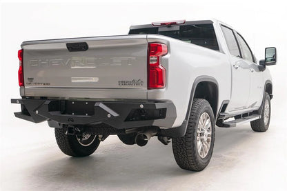 Fab Fours Vengeance rear bumper on a silver Chevrolet Silverado 2500HD, rear passenger-side three-quarter view, showing the honeycomb light pods, angular end caps and license plate recess