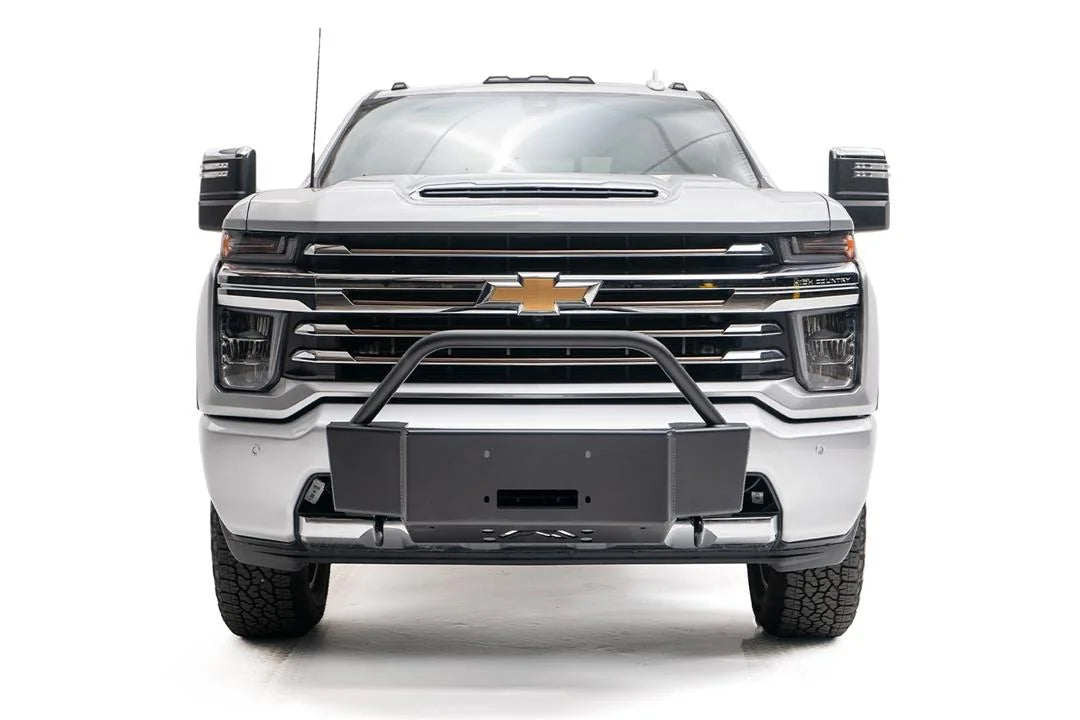 Fab Fours winch mount with pre-runner guard on a white Chevrolet Silverado 2500HD, straight-on front view, showing the pre-runner hoop, winch mount plate and fairlead opening