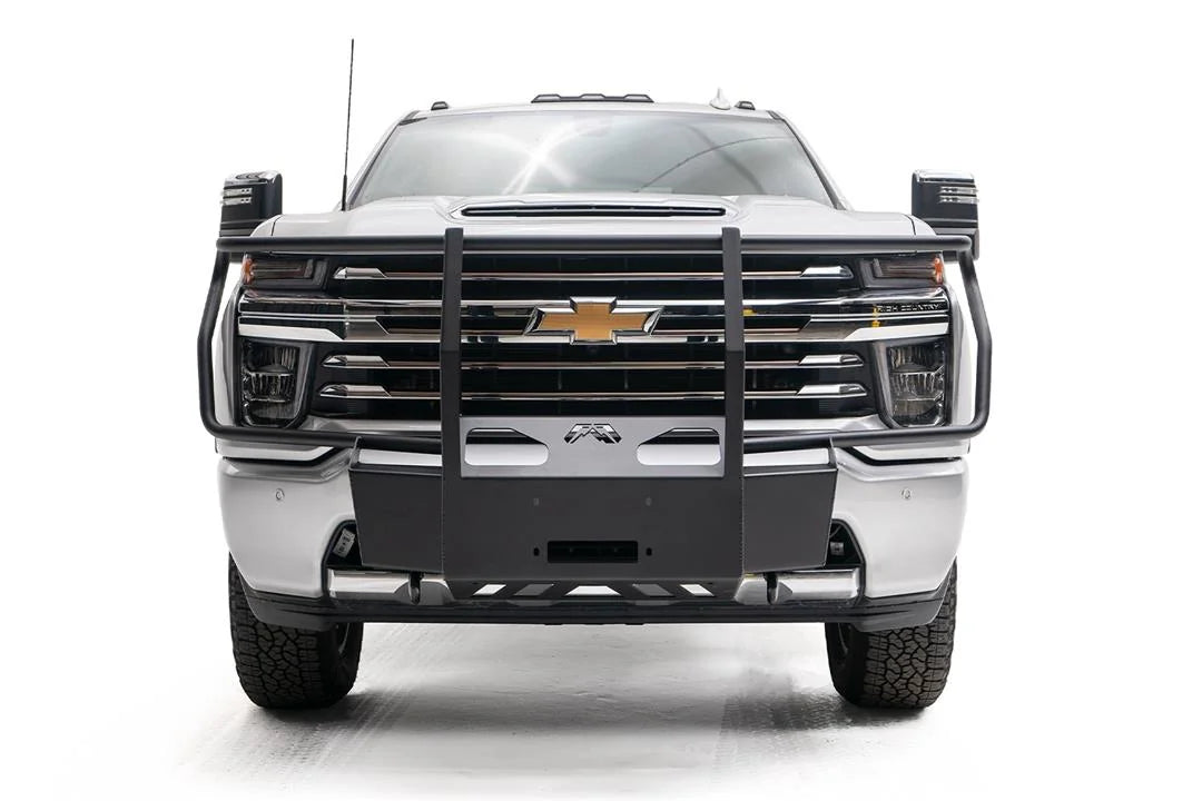 Fab Fours winch mount with full guard on a white Chevrolet Silverado 2500HD, straight-on front view, showing the full grille guard uprights, winch mount plate and Fab Fours logo