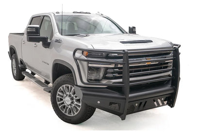 Fab Fours Black Steel Elite front bumper with full guard on a silver Chevrolet Silverado 2500HD, front passenger-side three-quarter view, showing the full grille guard, slotted skid plate and mesh light openings
