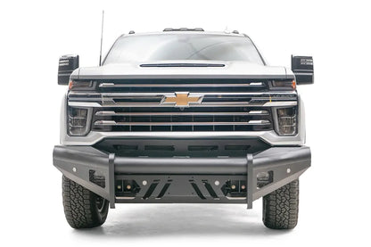 Fab Fours Black Steel Elite front bumper on a silver Chevrolet Silverado 2500HD, straight-on front view, showing the center tube uprights, slotted skid plate and mesh light openings
