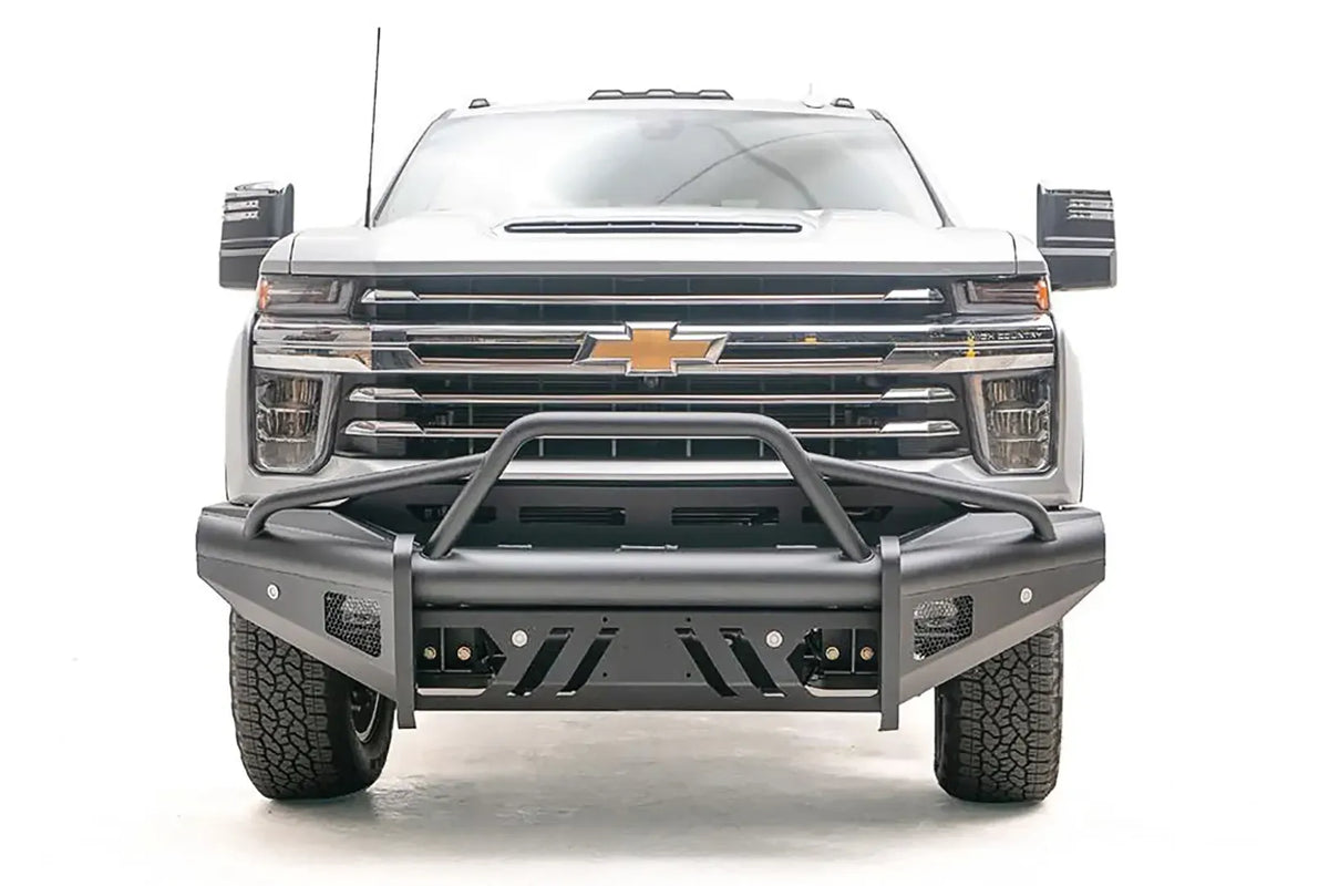 Fab Fours Black Steel Elite front bumper with pre-runner guard on a silver Chevrolet Silverado 2500HD, straight-on front view, showing the pre-runner guard tubing, slotted skid plate and mesh light openings