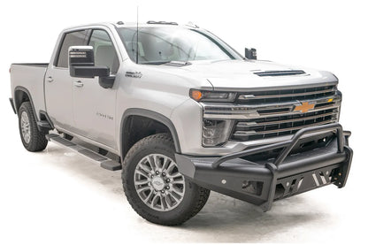 Fab Fours Black Steel Elite front bumper with pre-runner guard on a silver Chevrolet Silverado 2500HD, front passenger-side three-quarter view, showing the pre-runner guard, slotted skid plate and mesh light openings