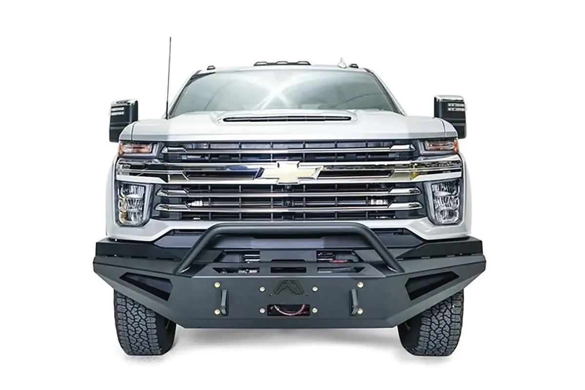 Fab Fours Red Steel front bumper with pre-runner guard on a white Chevrolet Silverado 2500HD, straight-on front view, showing the pre-runner guard tubing, angular bumper face, Fab Fours logo and winch hook