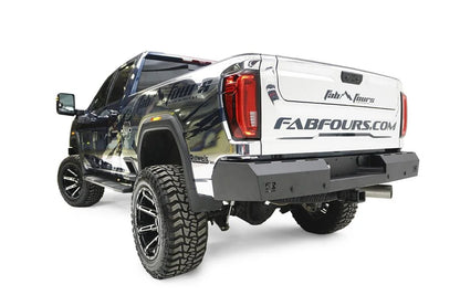 Fab Fours Red Steel rear bumper on a chrome-wrapped GMC Sierra HD, rear driver-side three-quarter view, showing the flat bumper face, integrated light cutouts and wrap-around ends