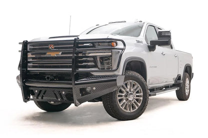 Fab Fours Black Steel front bumper with full guard on a white Chevrolet Silverado 2500HD, front driver-side three-quarter view, showing the full grille guard hoops, diamond-plate end caps and lower skid openings