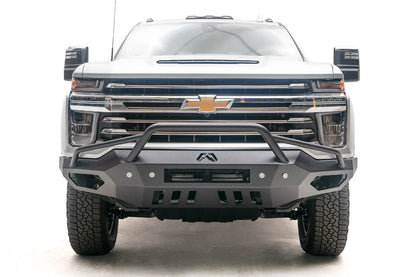 Fab Fours Vengeance front bumper with pre-runner guard on a white Chevrolet Silverado 2500HD, straight-on front view, showing the tubular pre-runner hoop, center light bar cutout and slotted skid plate