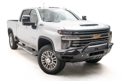 Fab Fours Vengeance front bumper with pre-runner guard on a white Chevrolet Silverado 2500HD, front passenger-side three-quarter view, showing the pre-runner hoop, angular bumper wing and lower skid plate