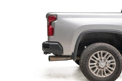 Fab Fours Premium rear bumper on a silver Chevrolet Silverado 2500HD, close-up of the rear corner, showing the wraparound end cap and its clearance behind the rear wheel