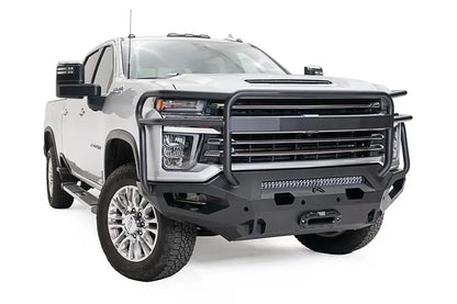 Fab Fours Matrix front bumper with full guard on a white Chevrolet Silverado 2500HD, front driver-side three-quarter view, showing the tubular full grille guard, integrated light bar and recessed winch mount