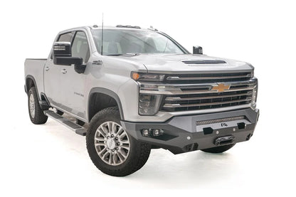 Fab Fours Matrix front bumper on a silver Chevrolet Silverado 2500HD, front passenger-side three-quarter view, showing the no-guard design, integrated light bar and recessed winch mount