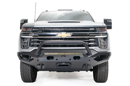 Fab Fours Matrix front bumper with pre-runner guard on a white Chevrolet Silverado 2500HD, straight-on front view, showing the tubular pre-runner hoop, center light bar and winch mount