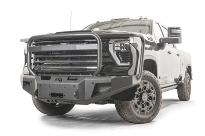 Fab Fours Premium Winch front bumper with full guard on a dark gray Chevrolet Silverado 2500HD, front driver-side three-quarter view, showing the tubular full grille guard, winch mount opening and angled end wings