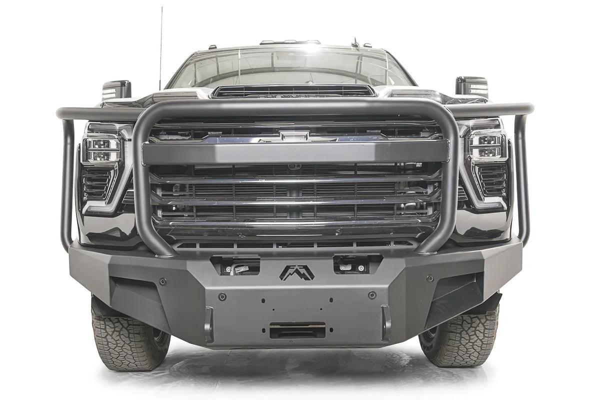 Fab Fours Premium Winch front bumper with full guard on a dark gray Chevrolet Silverado 2500HD, straight-on front view, showing the full-width tubular guard, center winch fairlead opening and logo cutout